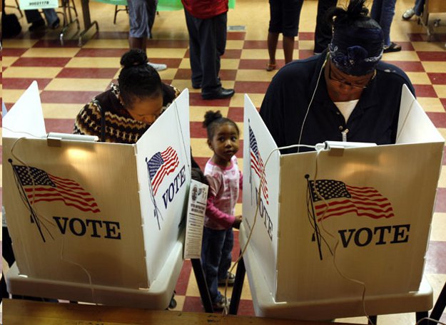 A contemporary photo shows two Black women voters filling out their ballots behind privacy screens decorated with American flags and the words "VOTE". Between them a little Black girl looks up at them.